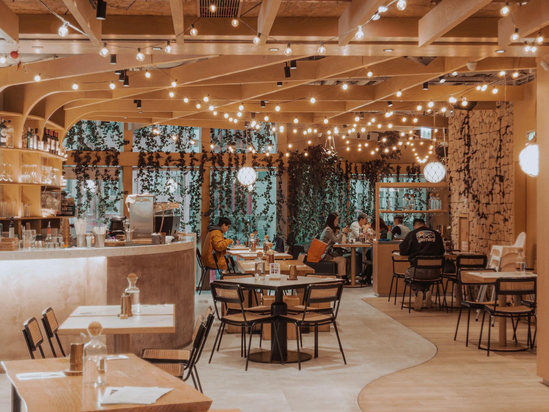 Sala de un restaurante llena por la noche, con guirnaldas de luces cálidas